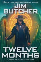 Cover for TWELVE MONTHS by Jim Butcher. Harry Dresden - wearing a hat - stands in front of a glowing glyph.